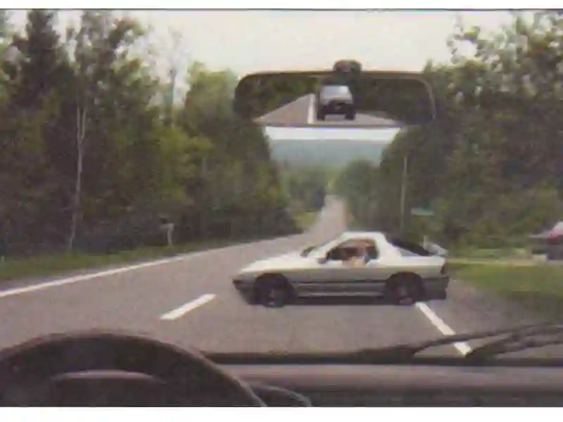 Imagine întrebare examen auto: Autoturismul alb execută manevra de întoarcere. Cum vei proceda corect?