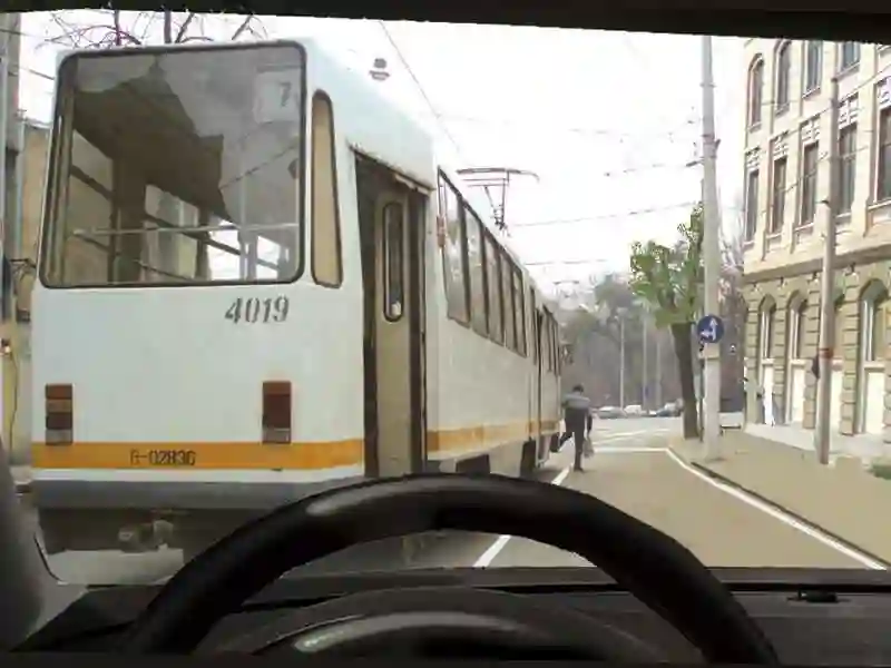 Imagine întrebare examen auto: Puteți depăși tramvaiul oprit în stație?