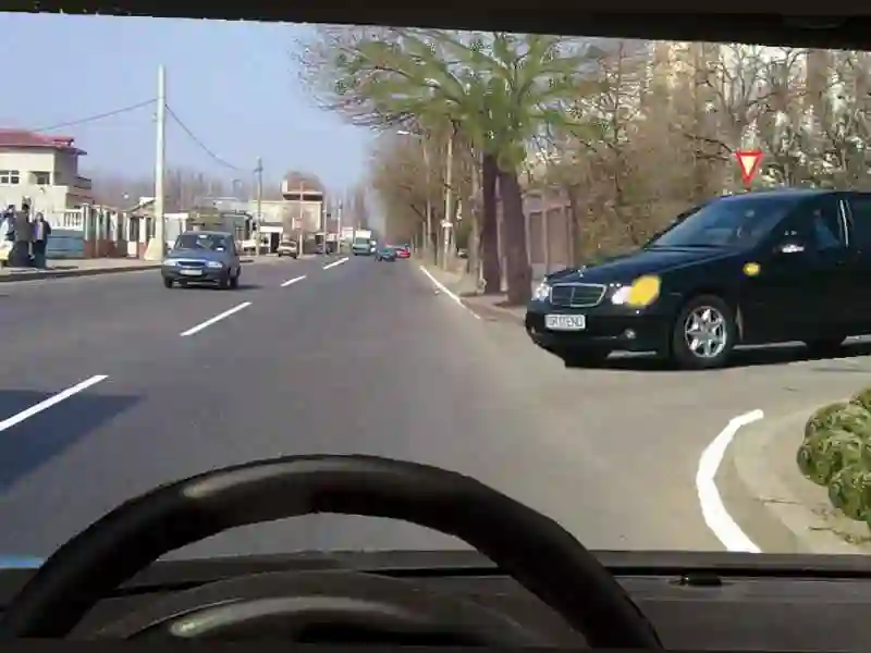Imagine întrebare examen auto: Trebuie să acordați prioritate autoturismului gri dacă acesta virează la stânga?