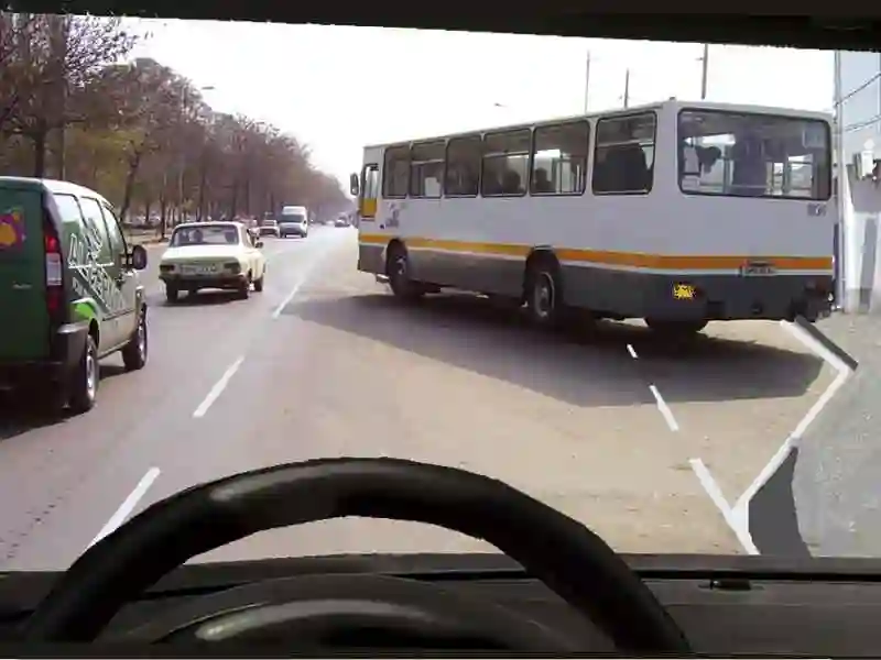 Imagine întrebare examen auto: Autobuzul din față semnalizează ieșirea din stația prevăzută cu alveolă. Cum trebuie